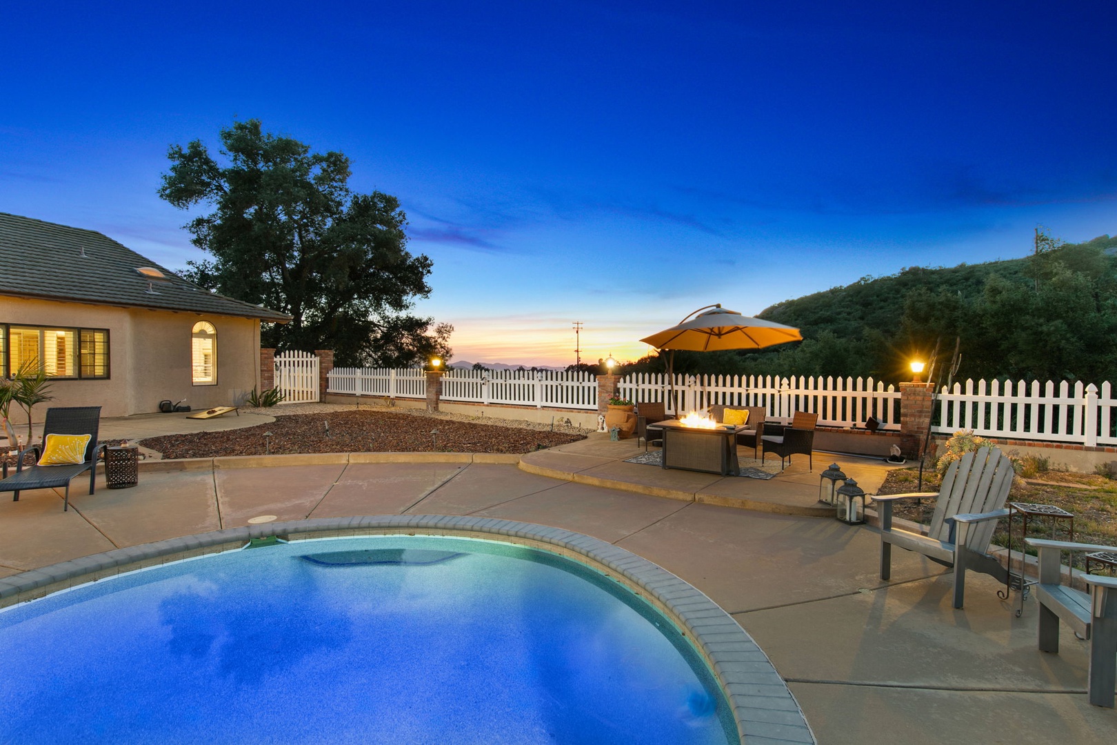 Unwind by the poolside fire pit as desert hills frame stunning sunset views. Your own outdoor oasis awaits.
