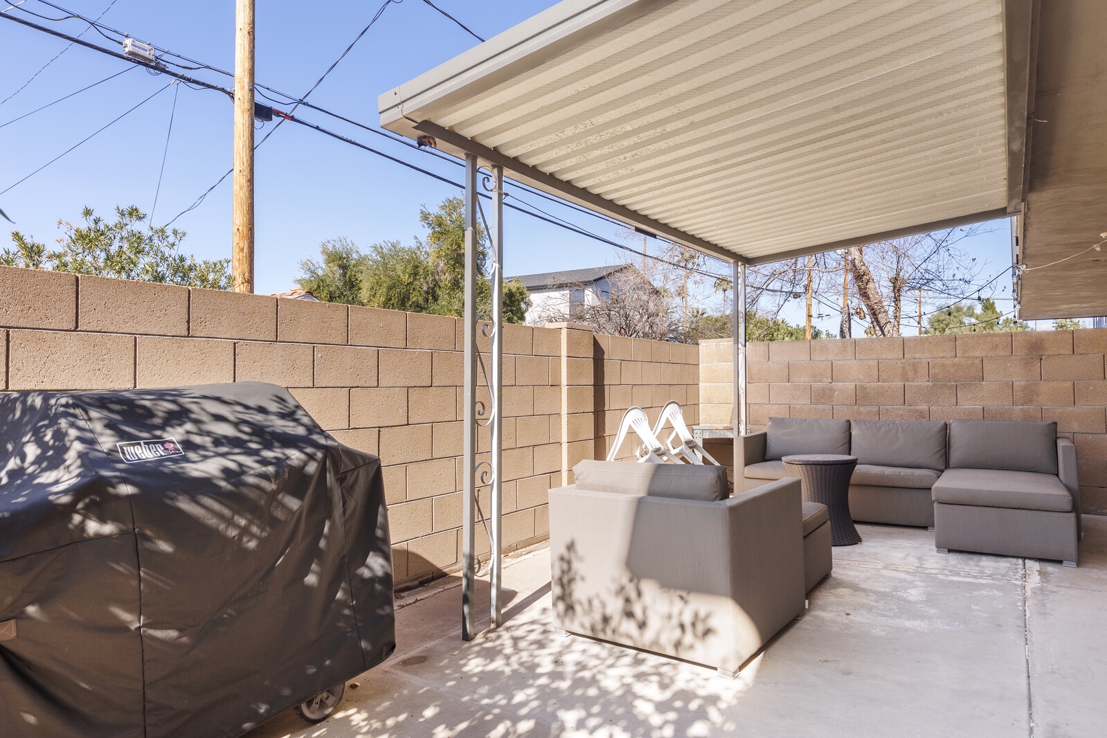 Back patio with covered lounge area and grill