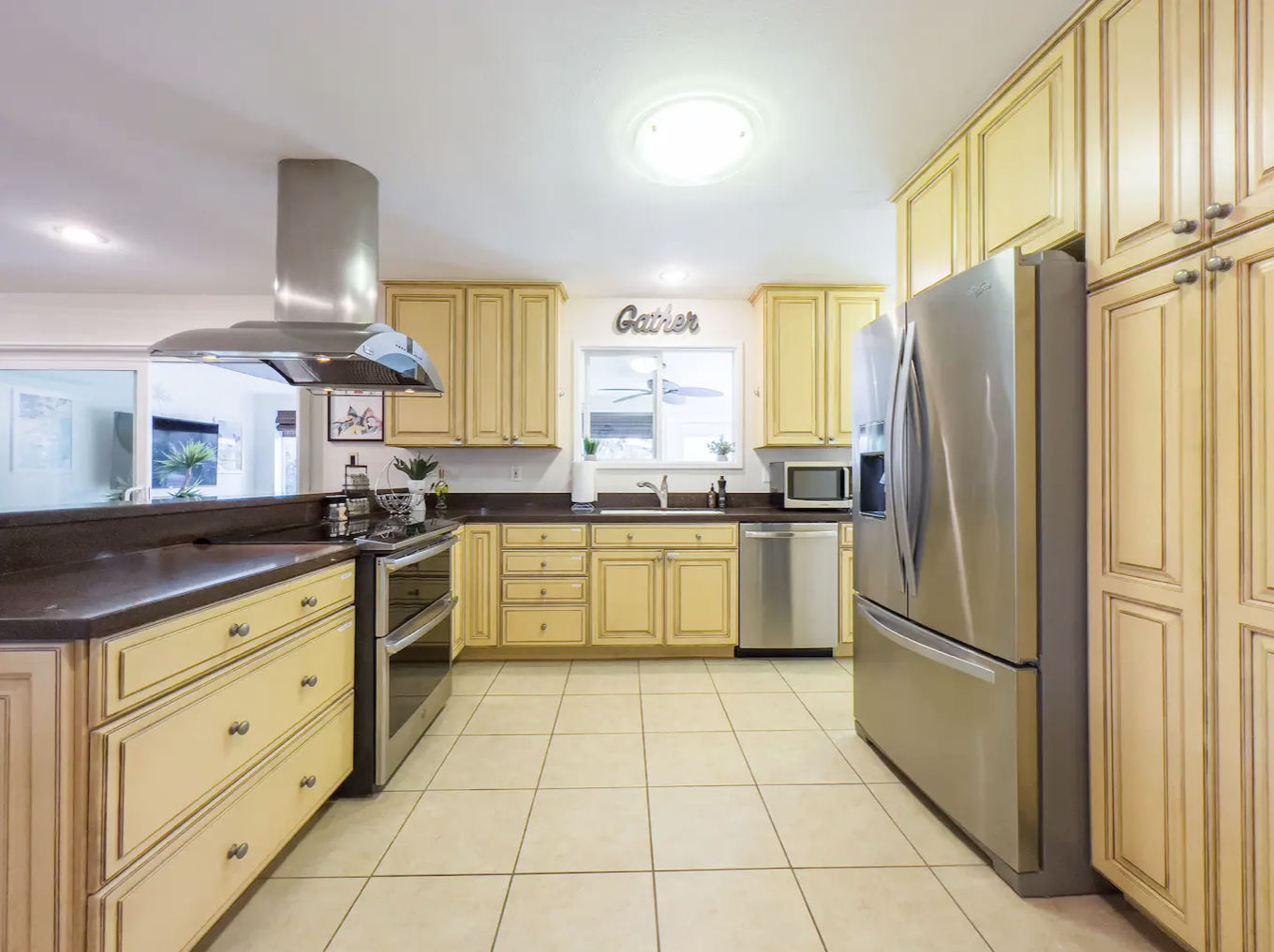 The kitchen has modern appliances including: dishwasher, fridge, blender, stove top, drip coffee maker, pots and pans, utensils.