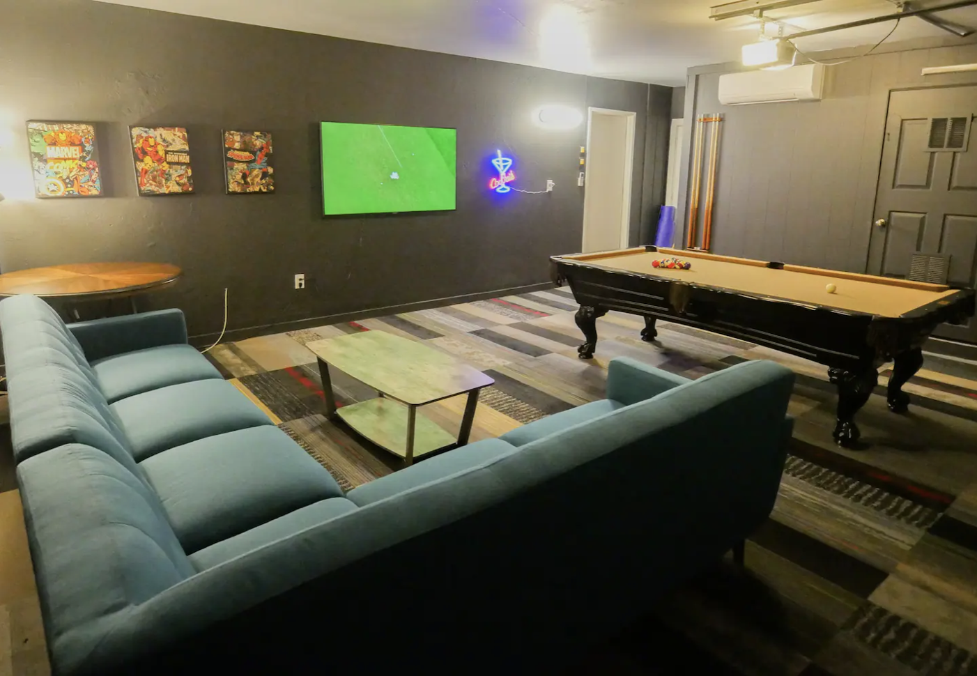 Temperature controlled game room with sofa sectional lounge, pool table, dart board, big screen smart tv.