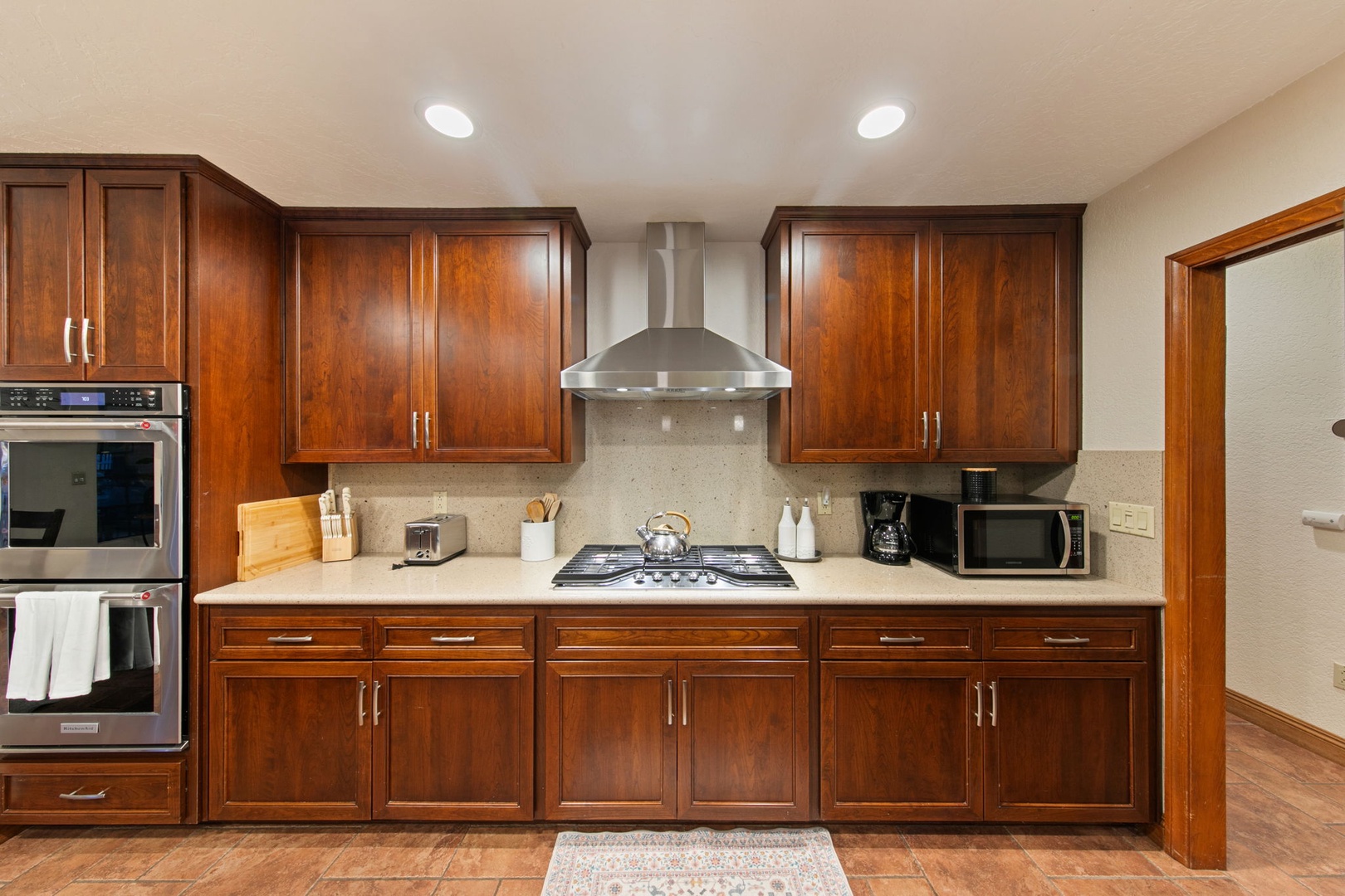 Your fully equipped kitchen awaits with rich cherry cabinets, granite countertops, and stainless steel appliances for memorable home-cooked meals.