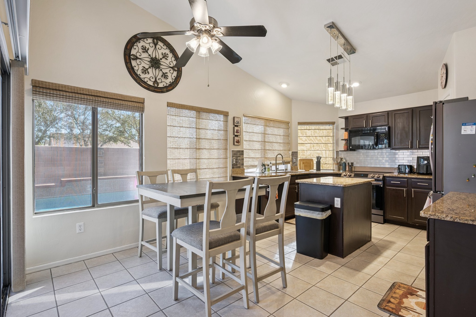 Your open kitchen flows into the dining area, where natural light streams through bamboo blinds as you prepare meals together.
