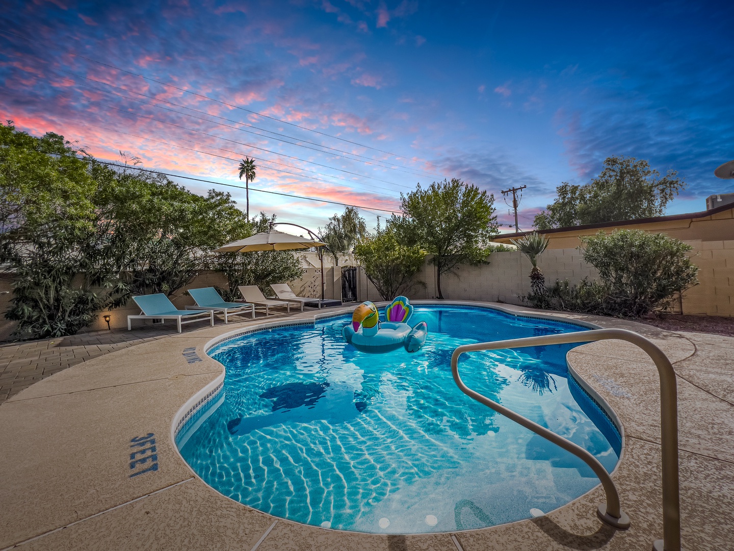 Sparkling pool, hot tub, patio lounge and table, fire pit, hammock chairs, and even a putting green to practice your short game