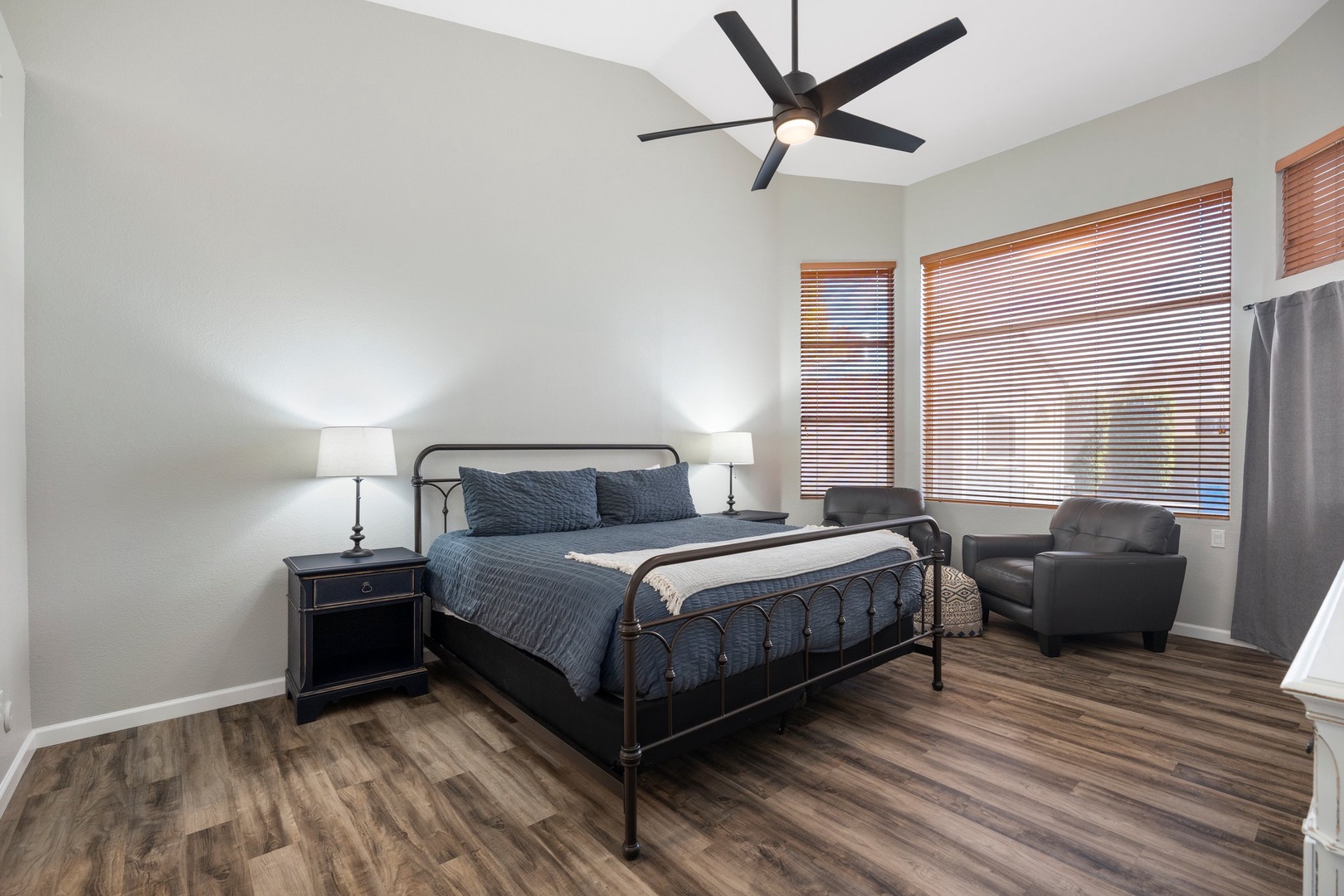 Primary Suite — King bed, ceiling fan, ensuite bath with dual-sink vanity, soaking tub, walk-in shower, and walk-in closet