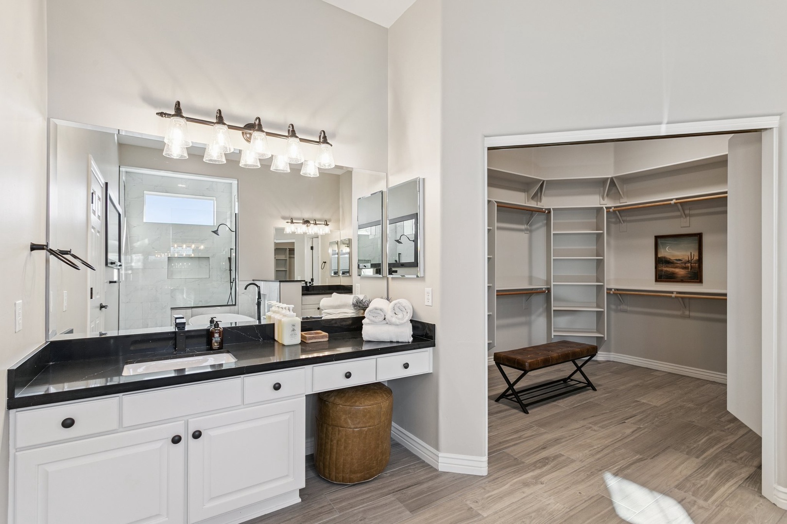 Primary ensuite bathroom with elegant lighting and premium fixtures, with a walk-in closet offering organized storage for your belongings.