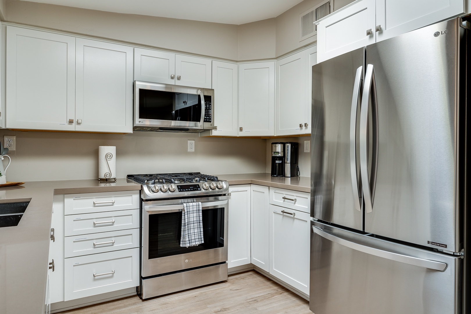 Modern appliances including: dishwasher, fridge, blender, stove top, coffee maker, pots and pans, utensils.