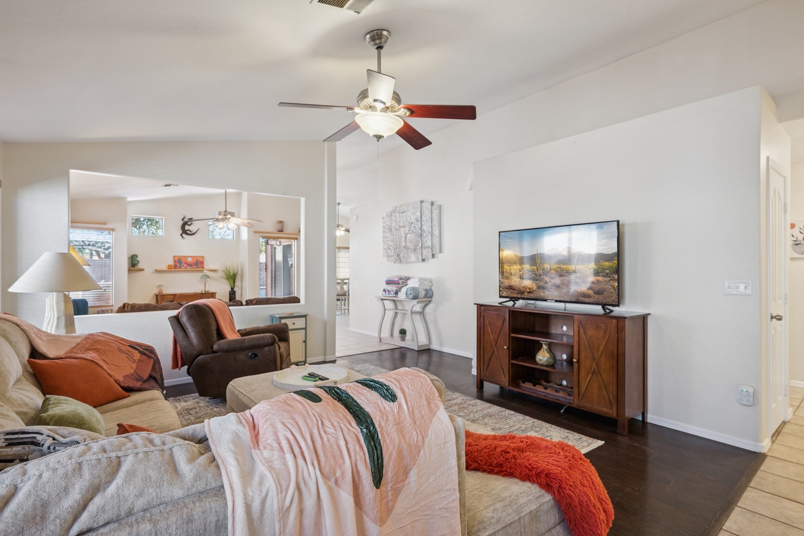 Relax in your cozy living room with plush seating, ceiling fan, and entertainment center for perfect movie nights.