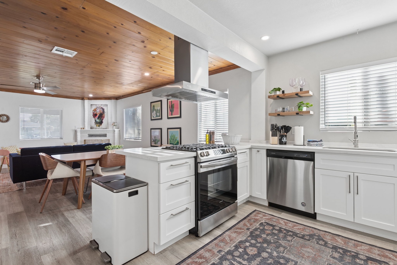 Your gourmet kitchen awaits with stainless steel appliances, white cabinetry, and warm wood ceiling creating the perfect culinary retreat.