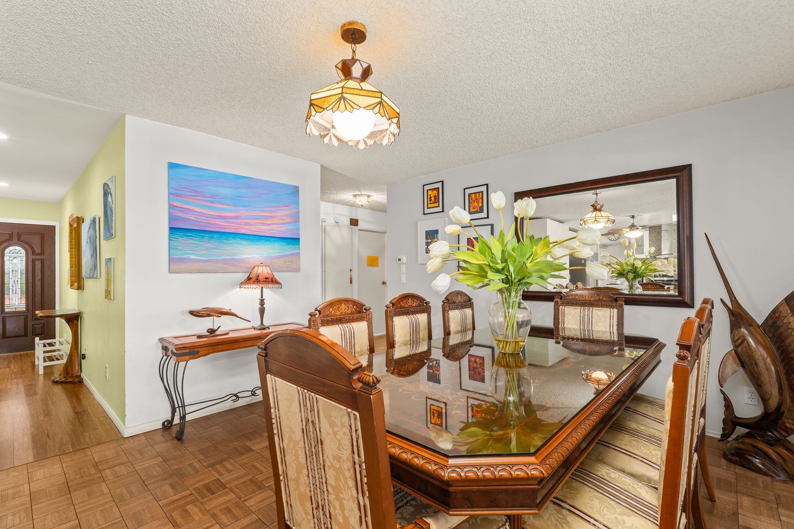 Gather around your elegant dining table under warm chandelier light, sharing memorable meals in this beautifully appointed space.