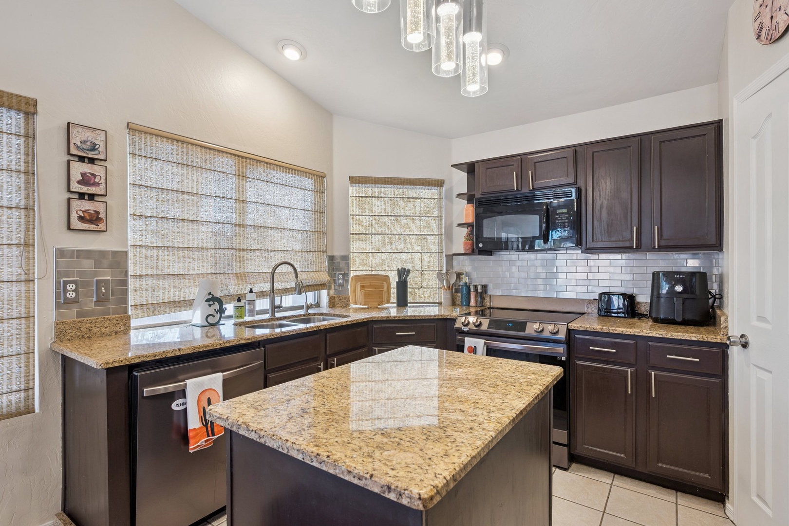 You'll love preparing meals in this fully equipped kitchen with granite countertops, modern appliances, and elegant pendant lighting.