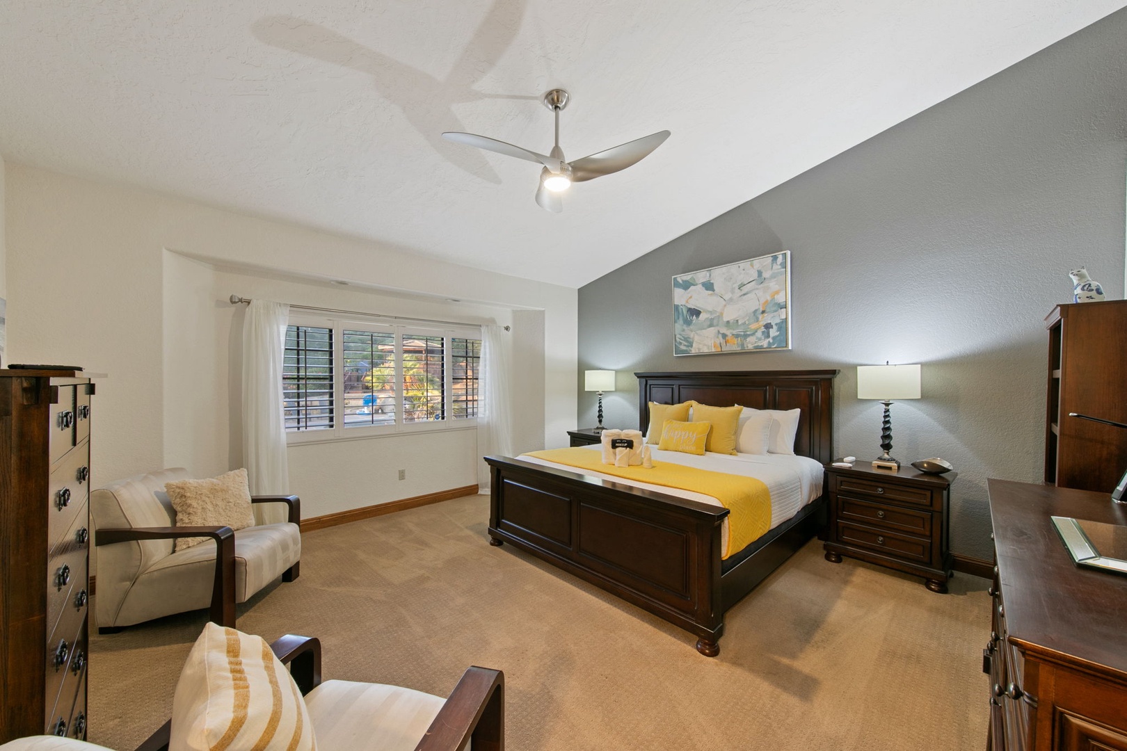 Unwind in your elegant primary suite featuring a plush king bed, cozy seating area, TV, and ensuite bathroom.