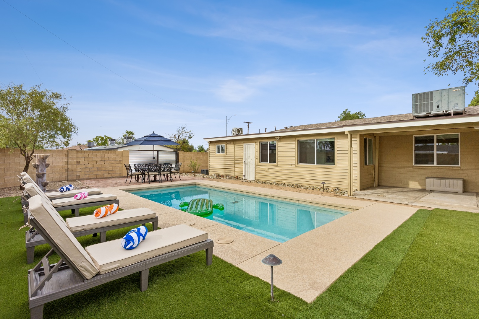 Soak up the Arizona sunshine in your private backyard oasis, where sun loungers line the sparkling pool and a shaded patio awaits leisurely meals outdoors.