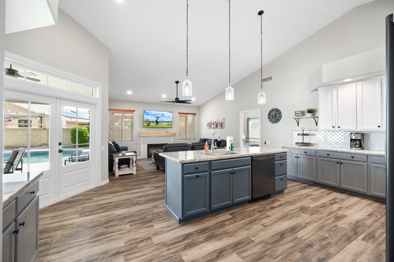Gorgeous open-concept kitchen and living space flooded with natural light. Soaring ceilings and a stylish island invite you to cook, gather, and relax—with pool views just steps away.
