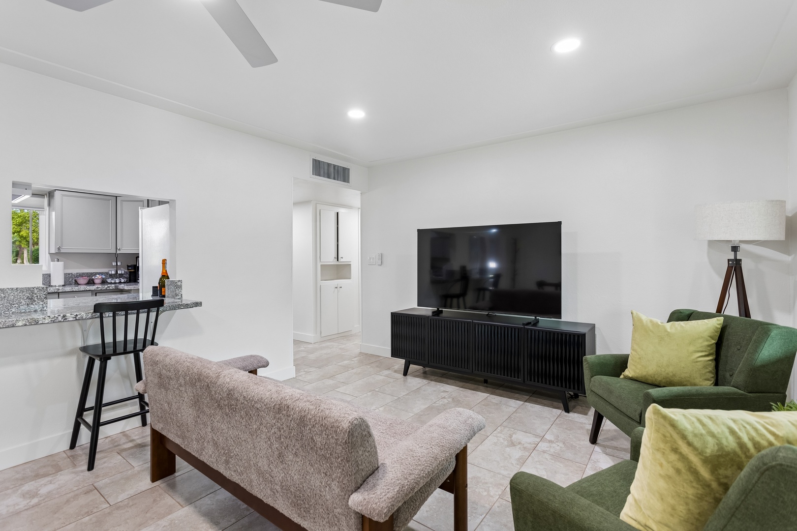 Step into your bright, modern living space where you can unwind on plush seating with cheerful accent pillows. The open layout flows seamlessly into the kitchen, perfect for relaxing evenings or entertaining.