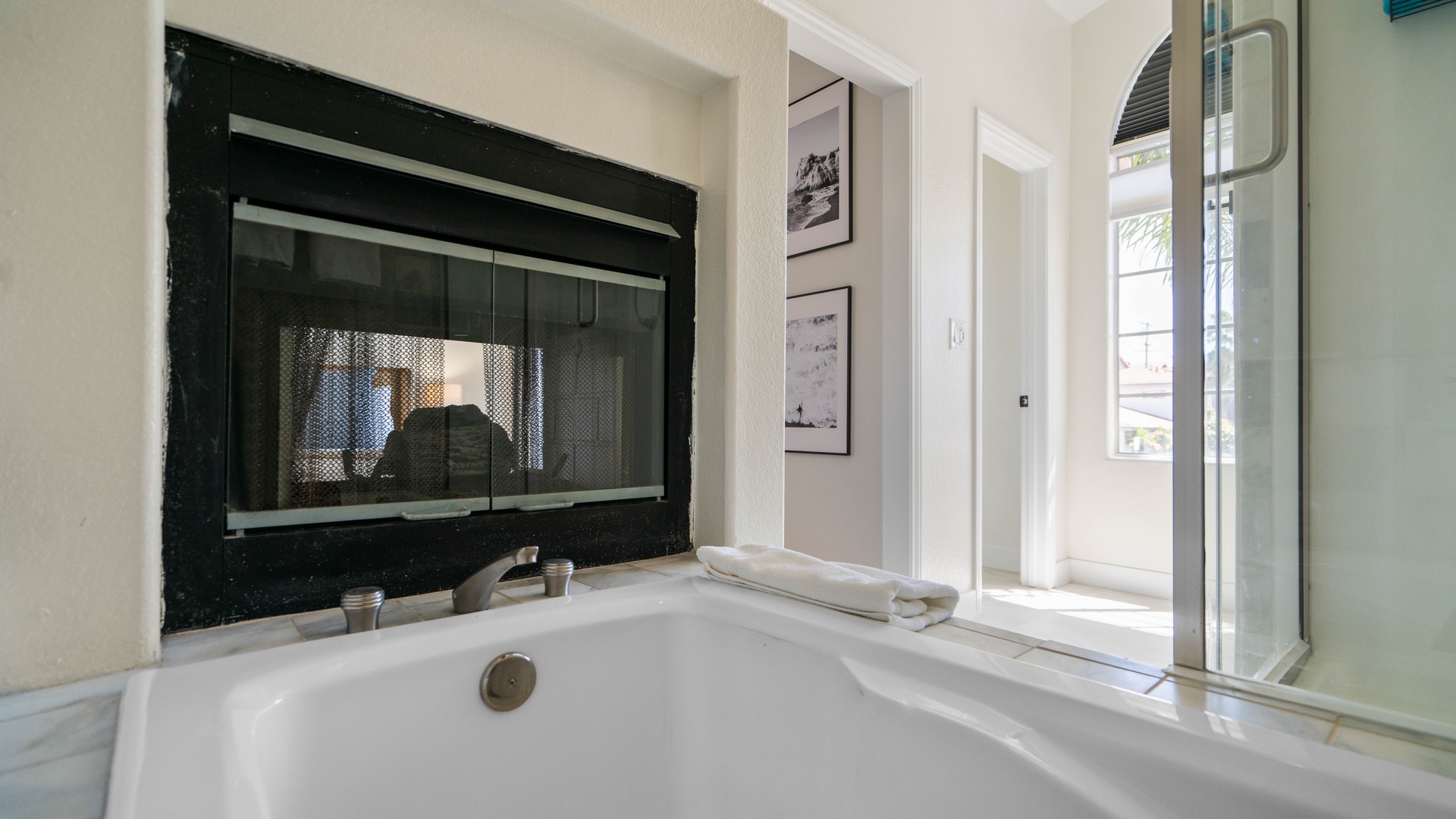 Primary Bedroom ensuite bathroom featuring a walk-in shower and soaking tub with see through fireplace