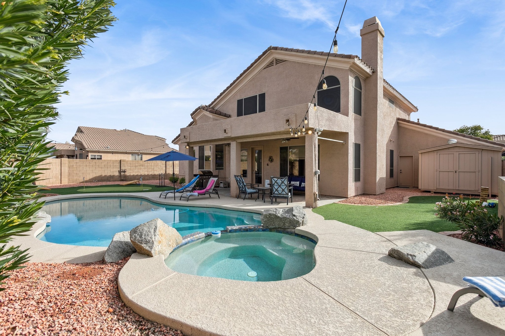 Stunning back yard featuring a sparkling pool and spa in a beautifully landscaped desert backyard.