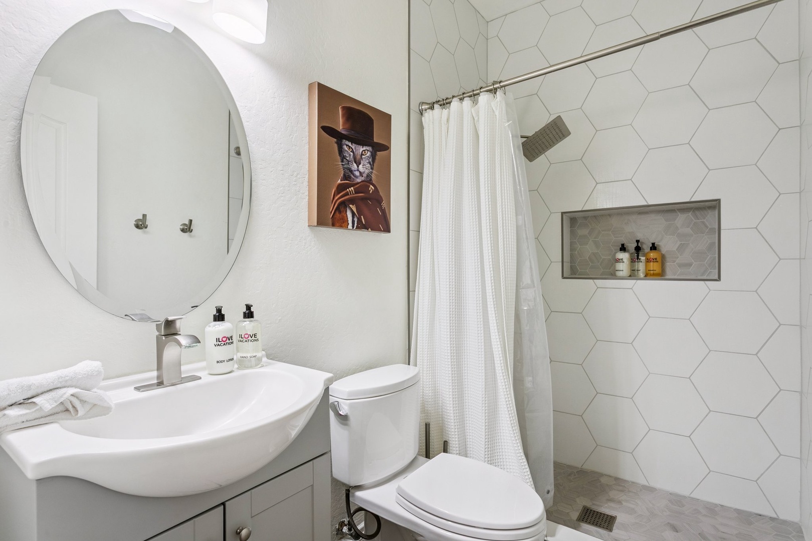 Refresh in your stylish bathroom featuring modern hexagonal tile, rainfall shower, and curated amenities for your perfect morning routine.