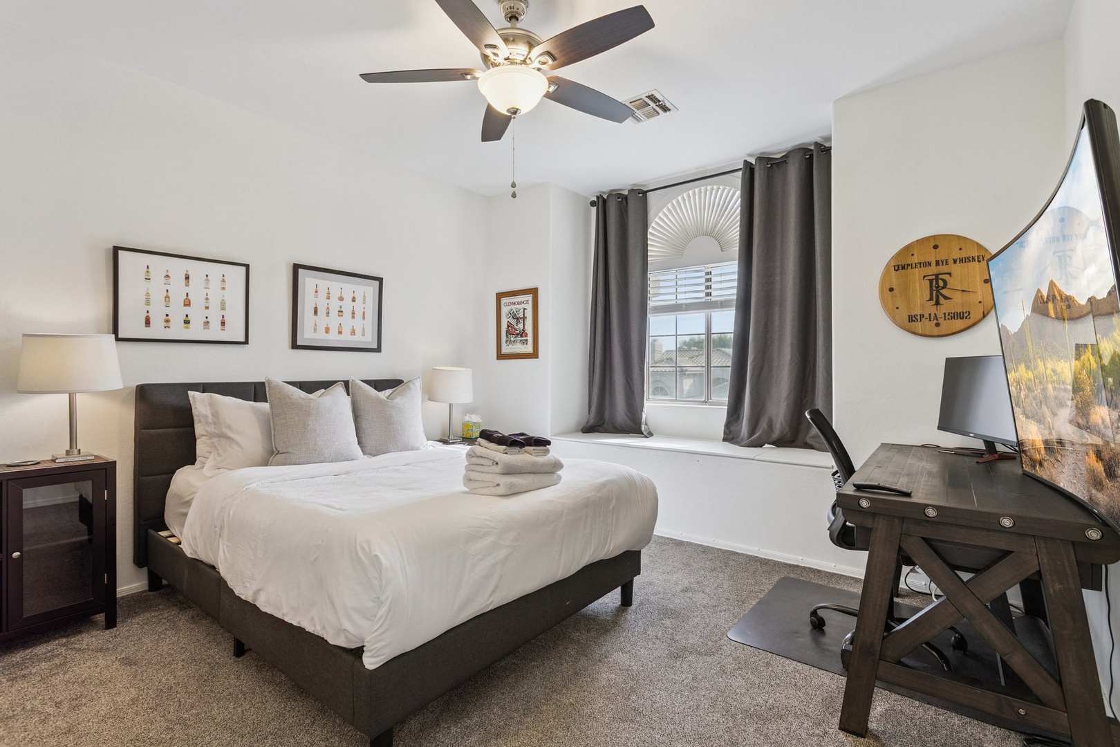 Unwind in your peaceful bedroom with comfy linens, gentle ceiling fan, and work desk for convenience.