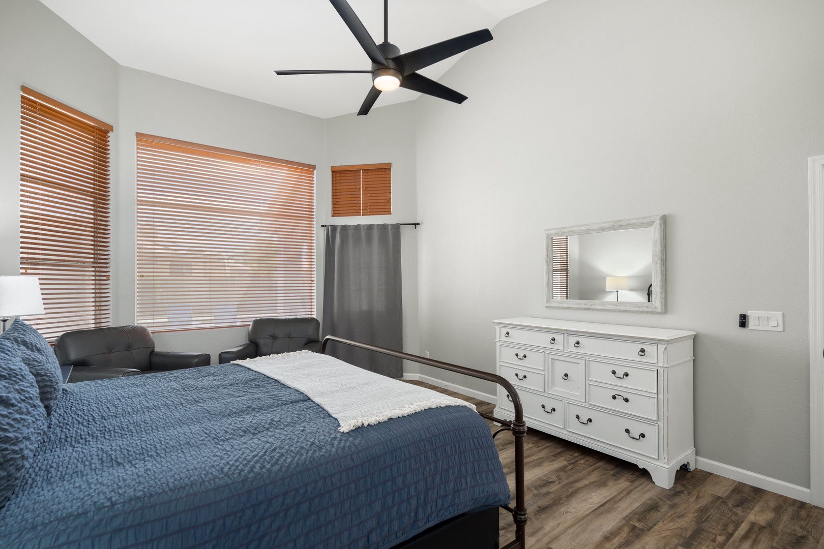 Primary Suite — King bed, ceiling fan, ensuite bath with dual-sink vanity, soaking tub, walk-in shower, and walk-in closet.