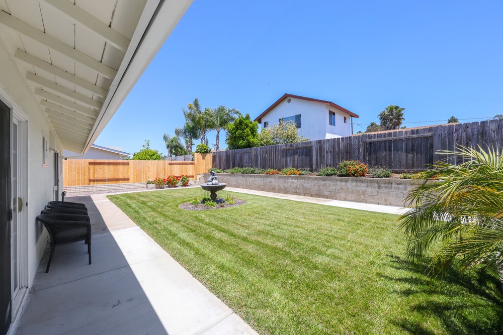 Private fenced backyard with fountain