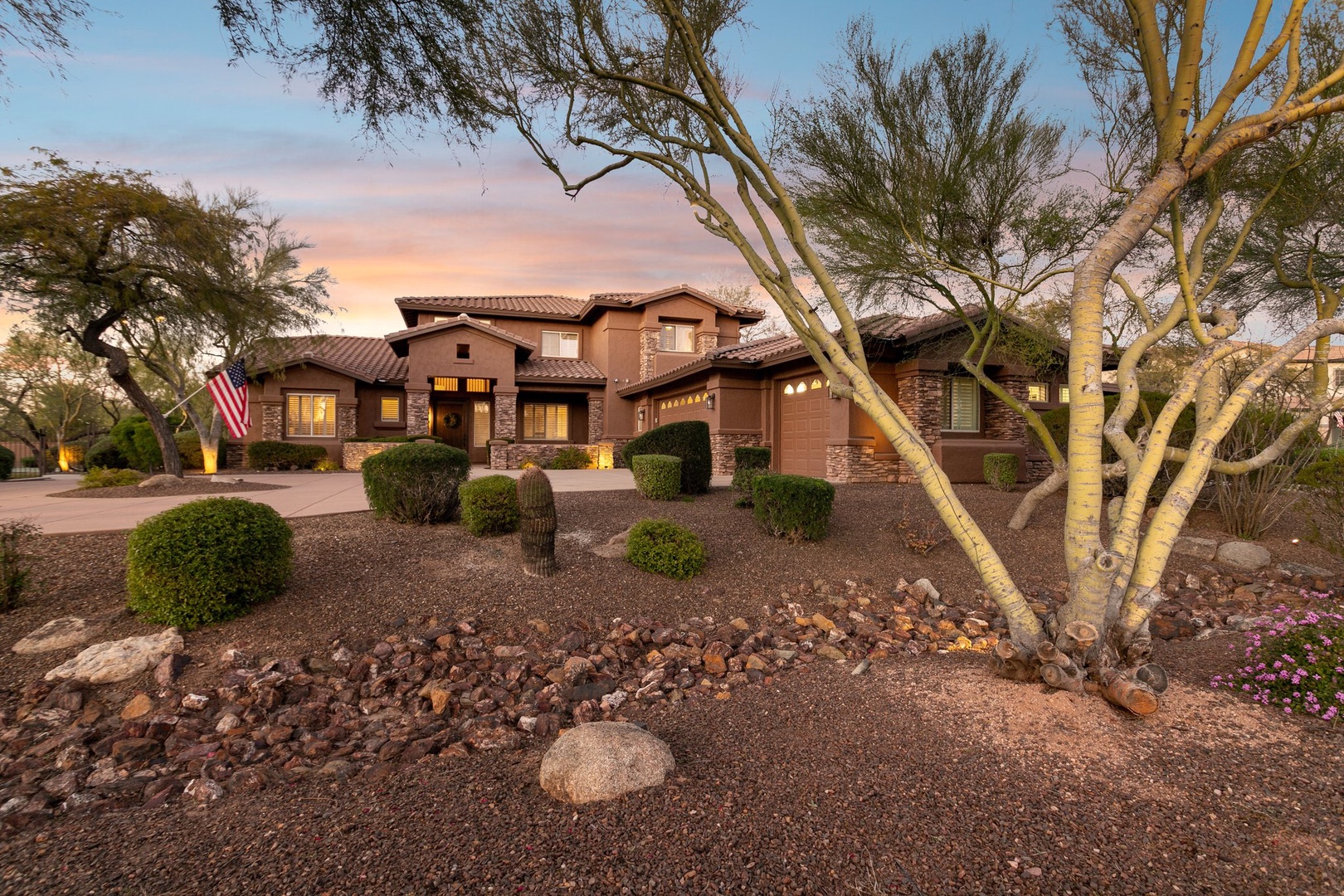 Elegant desert villa showcasing southwestern architecture with stone accents and desert landscaping at golden hour.