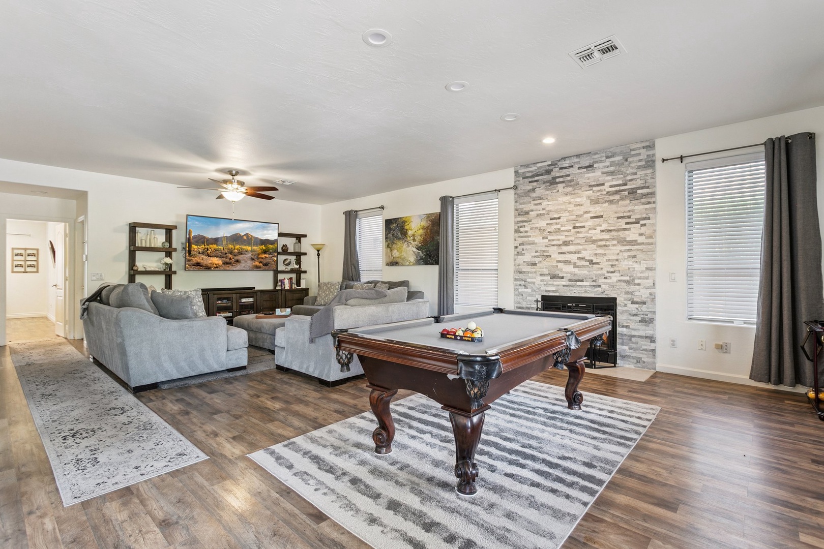 Unwind in your spacious game room with plush seating, pool table, and fireplace for cozy evening entertainment.