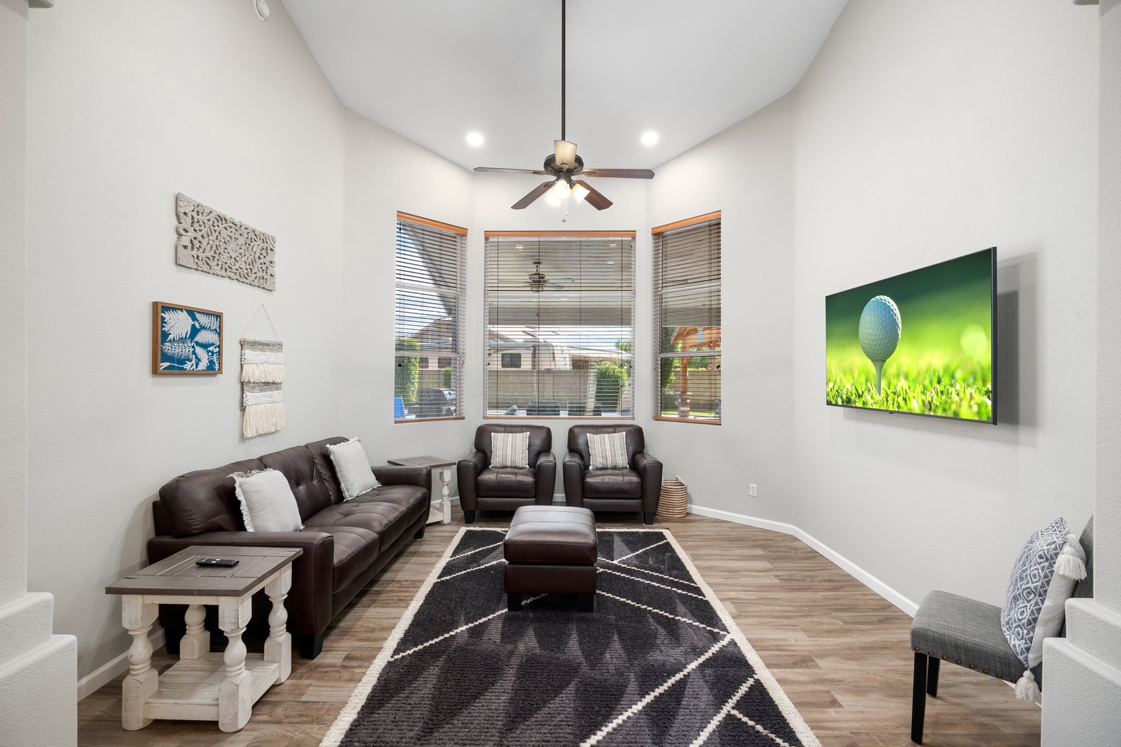 Step into your spacious living room with soaring vaulted ceilings and abundant natural light. Sink into plush leather seating for movie nights on the large flat-screen TV, or simply relax.