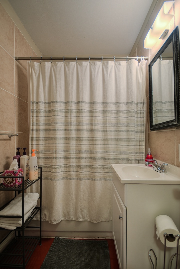 Clean and stocked bathroom with fresh towels, toiletries, and bath products for your use.