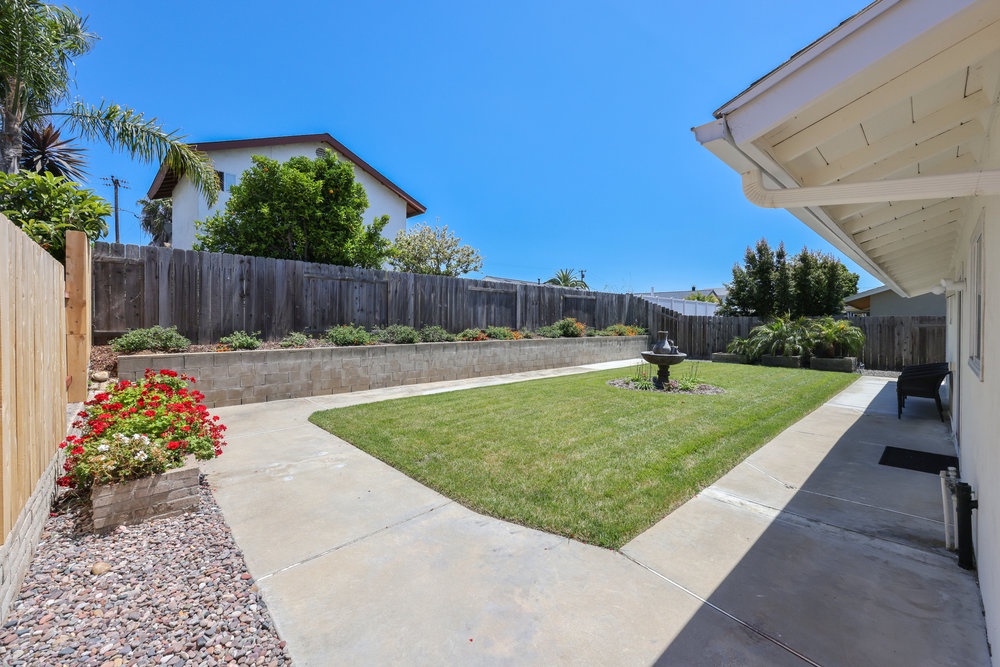 Private fenced backyard with fountain