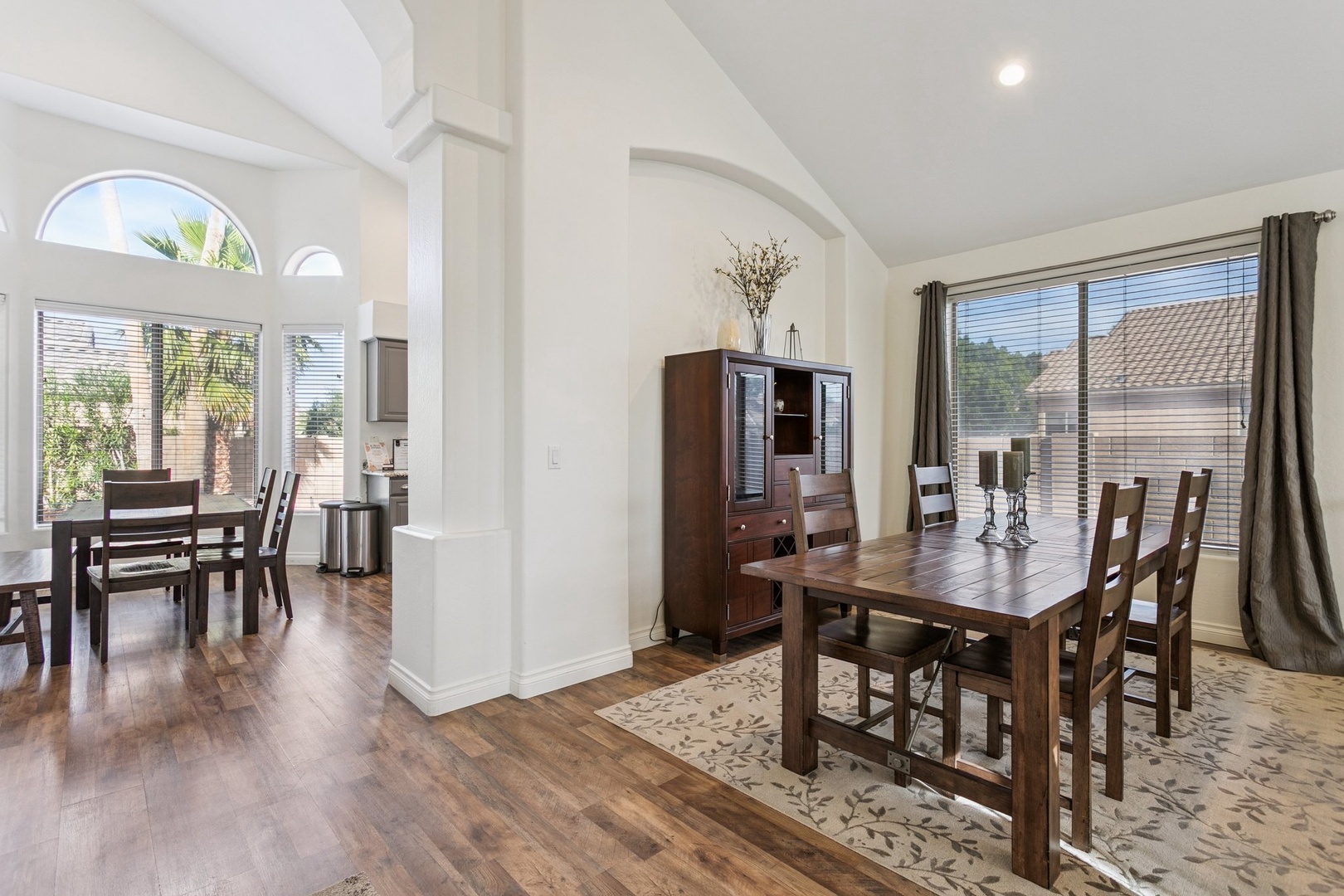Gather around this elegant dining table for memorable meals in your bright, open-plan home with soaring ceilings and warm wood floors.