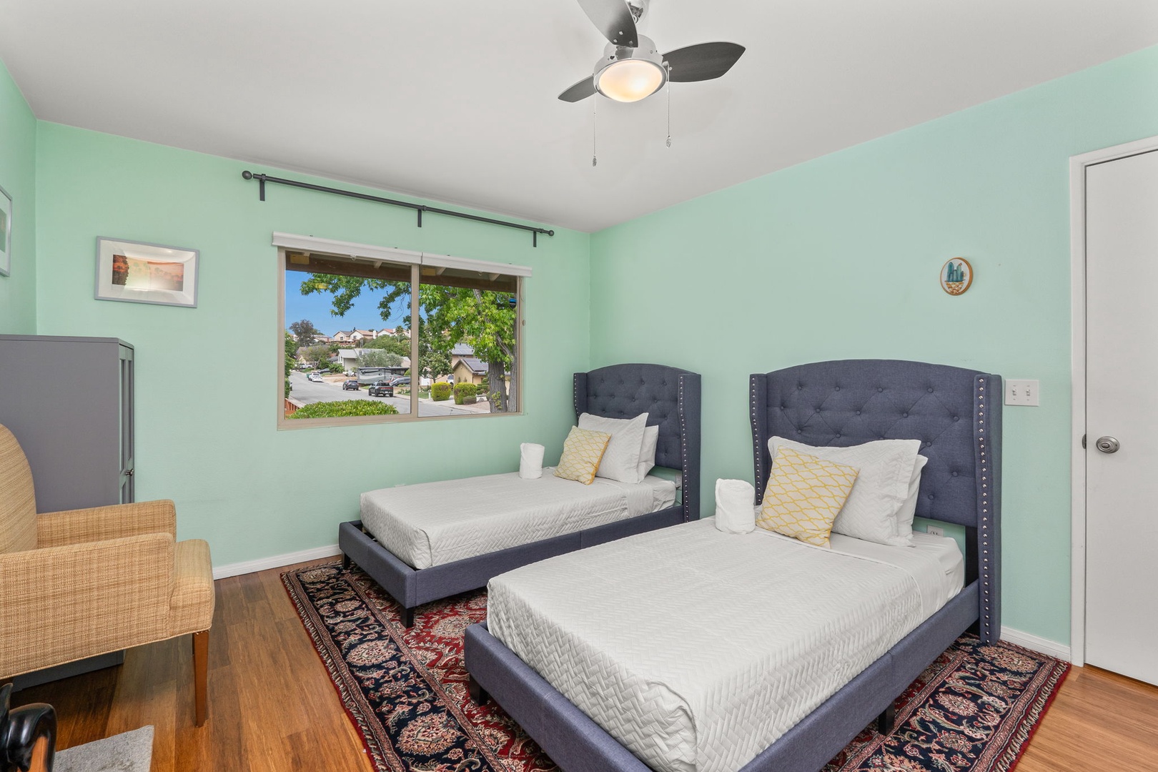 Two comfortable beds await in your bright bedroom, complete with gentle ceiling fan breezes and peaceful neighborhood views.