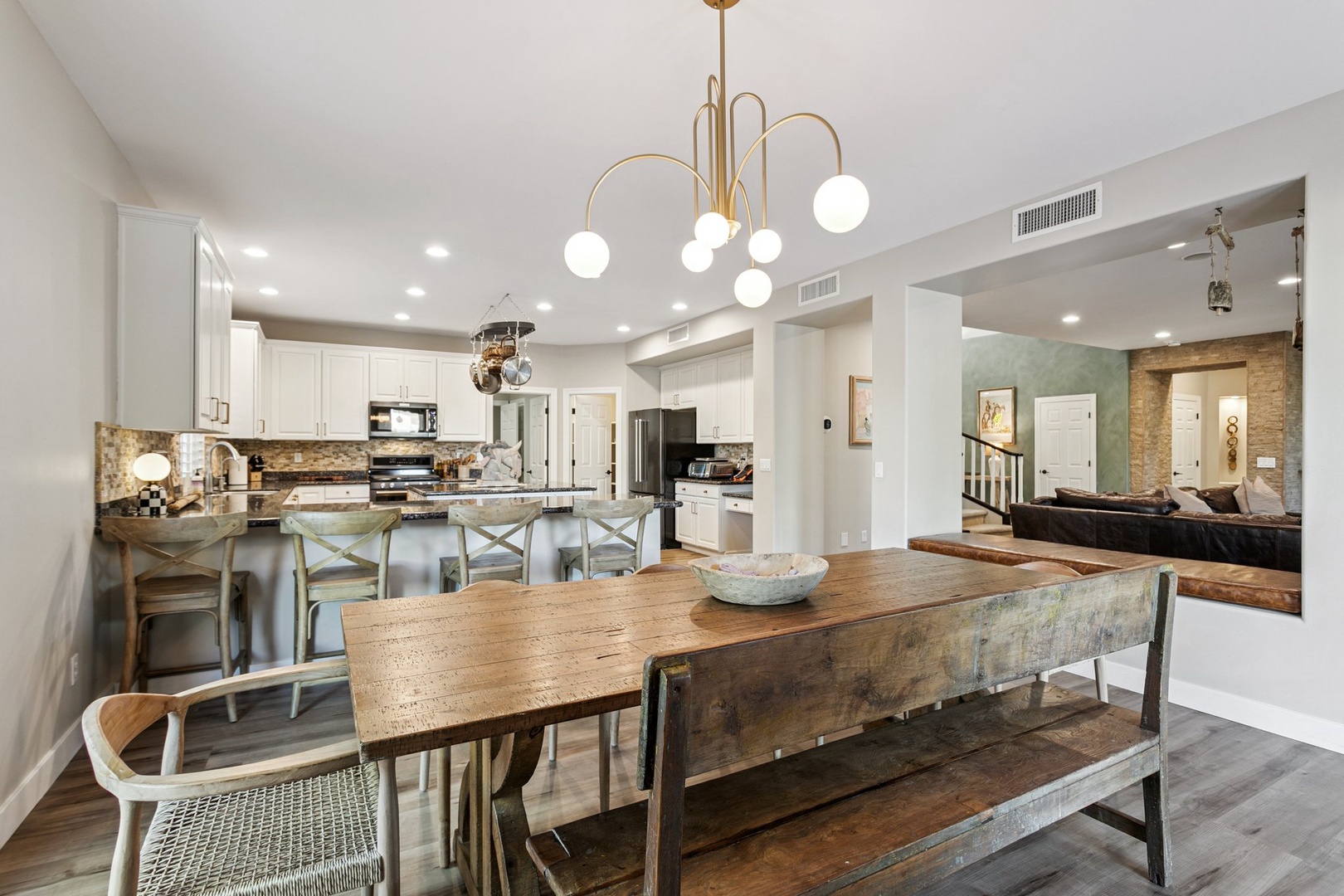 Gather around this rustic dining table while your gourmet kitchen awaits nearby, creating perfect moments for memorable meals together.