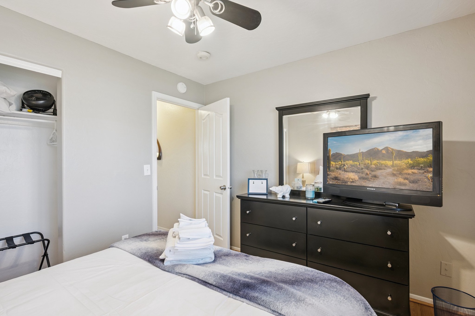 Relax in your peaceful bedroom with comfortable bedding, entertainment center, and thoughtful amenities for a restful stay.