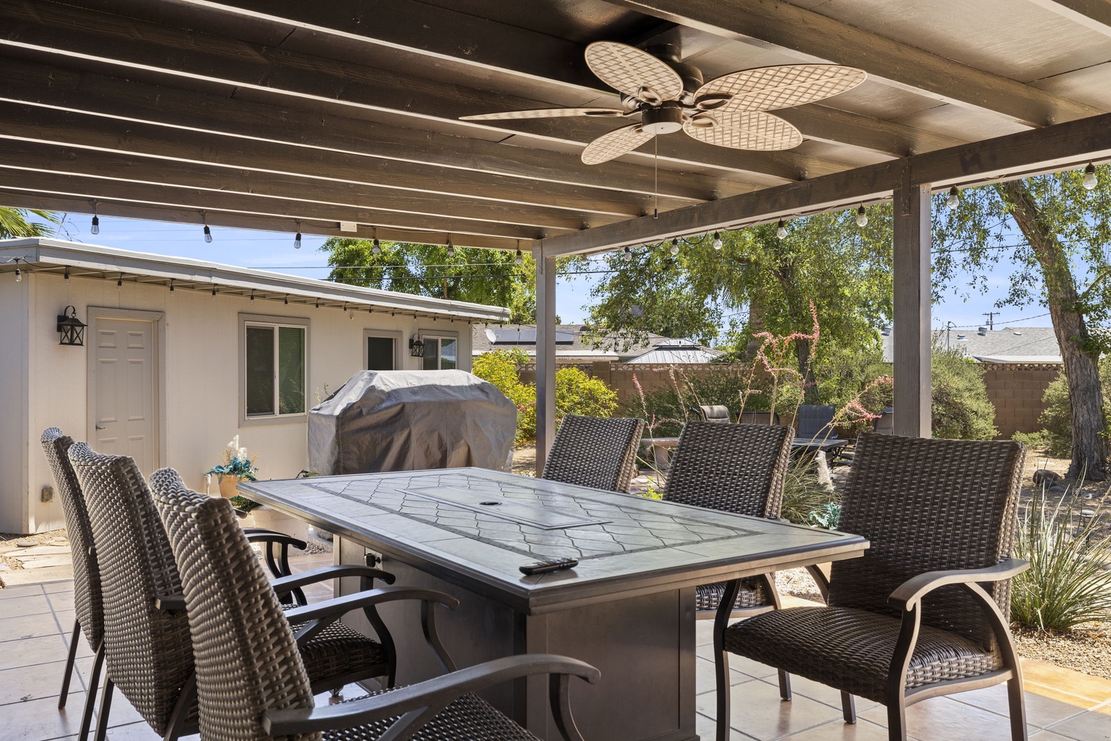 Outdoor lounge with hanging hammock chairs, fire pit table, and Flat Screen TV