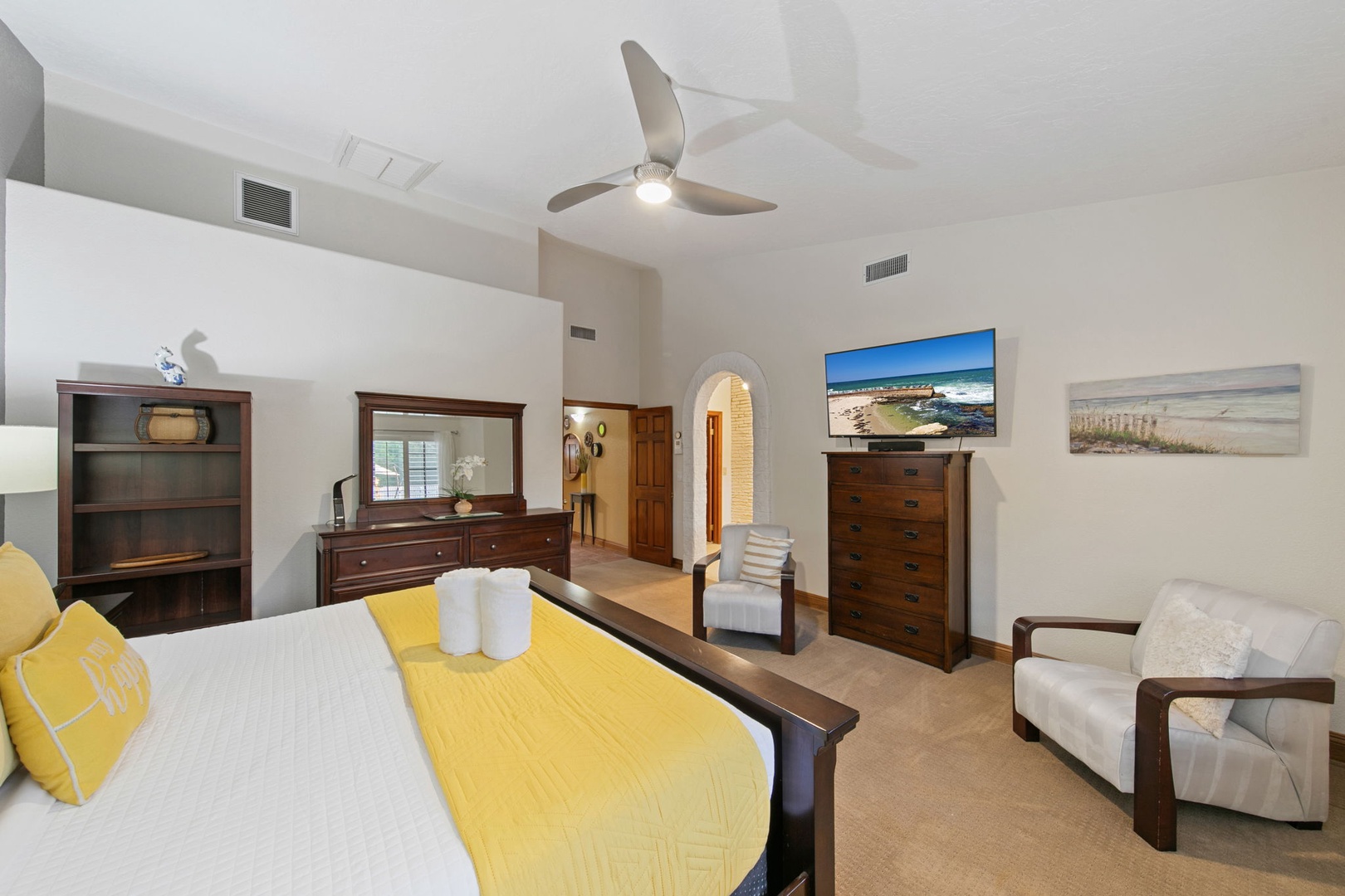 Unwind in your elegant primary suite featuring a plush king bed, cozy seating area, TV, and ensuite bathroom.