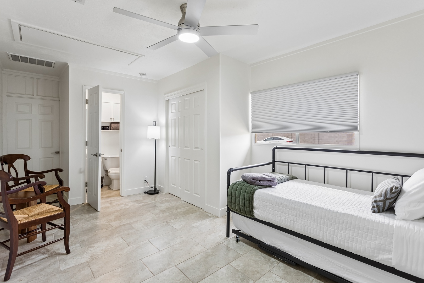 Unwind in your peaceful bedroom, where crisp white linens and cool tile floors invite restful sleep after a day of adventure.