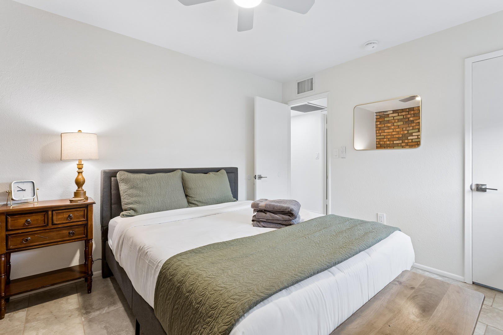 Relax in your peaceful bedroom featuring a plush queen bed dressed in soft linens, calming neutral tones, and warm bedside lighting. With your own ceiling fan and climate control, you'll drift into a restful sleep.