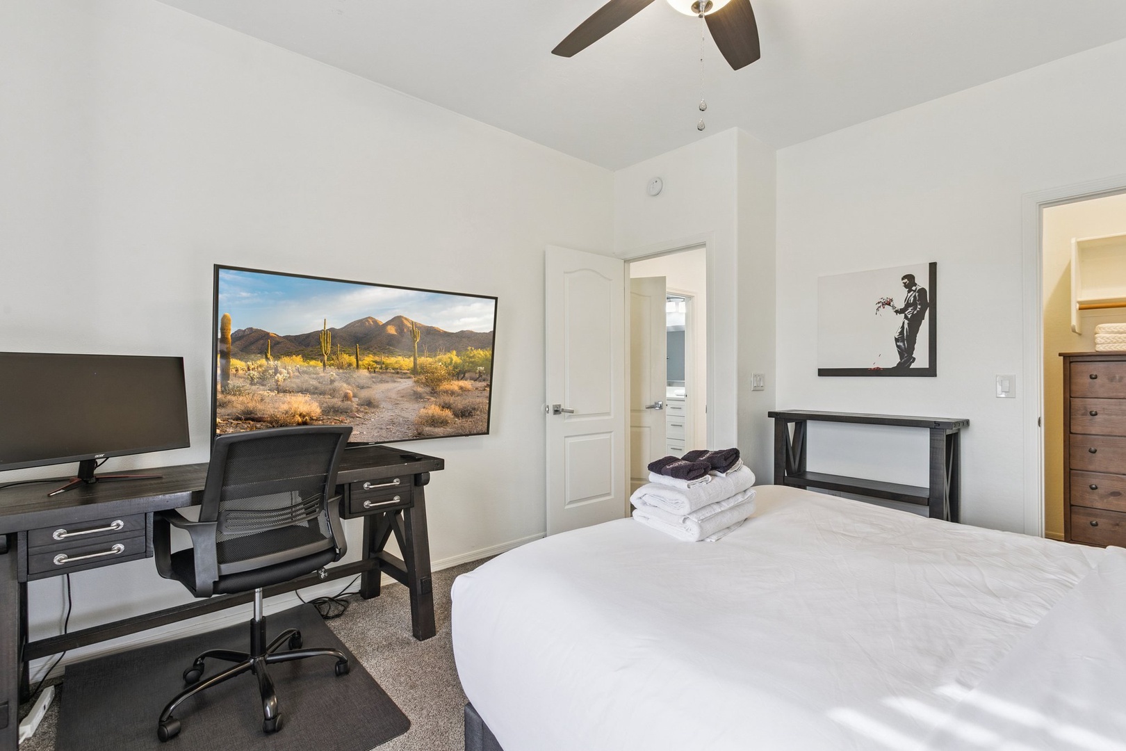 Rest easy in your bright bedroom with a large TV for entertainment and a dedicated workspace for productivity.