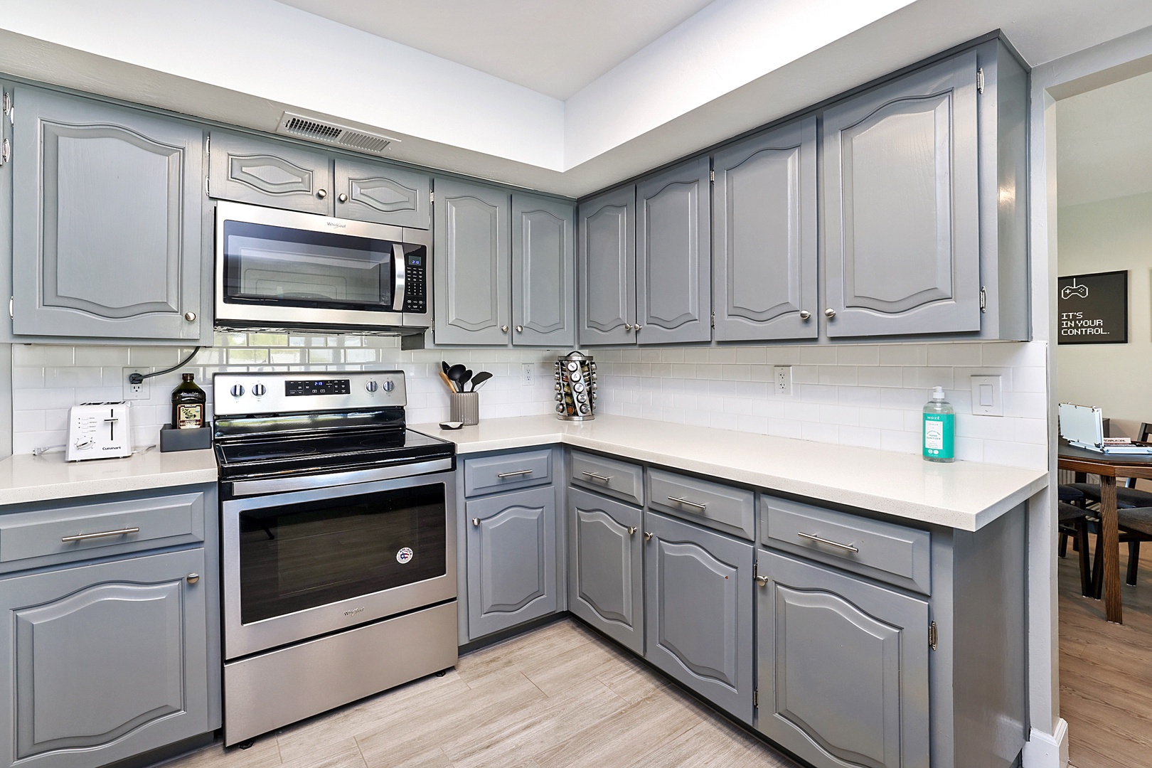 modern stainless steel appliances including: dishwasher, fridge, oven, microwave, stove top, coffee maker, pots and pans, and utensils.