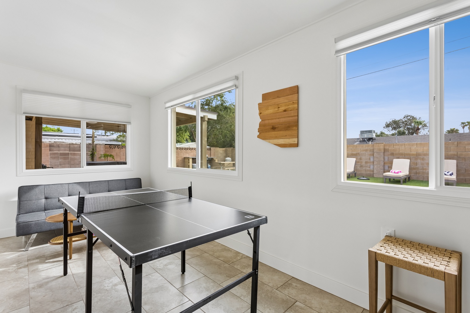 Challenge friends to a spirited ping pong match in your private game room, where natural light streams through wide windows and opens onto your own backyard retreat.