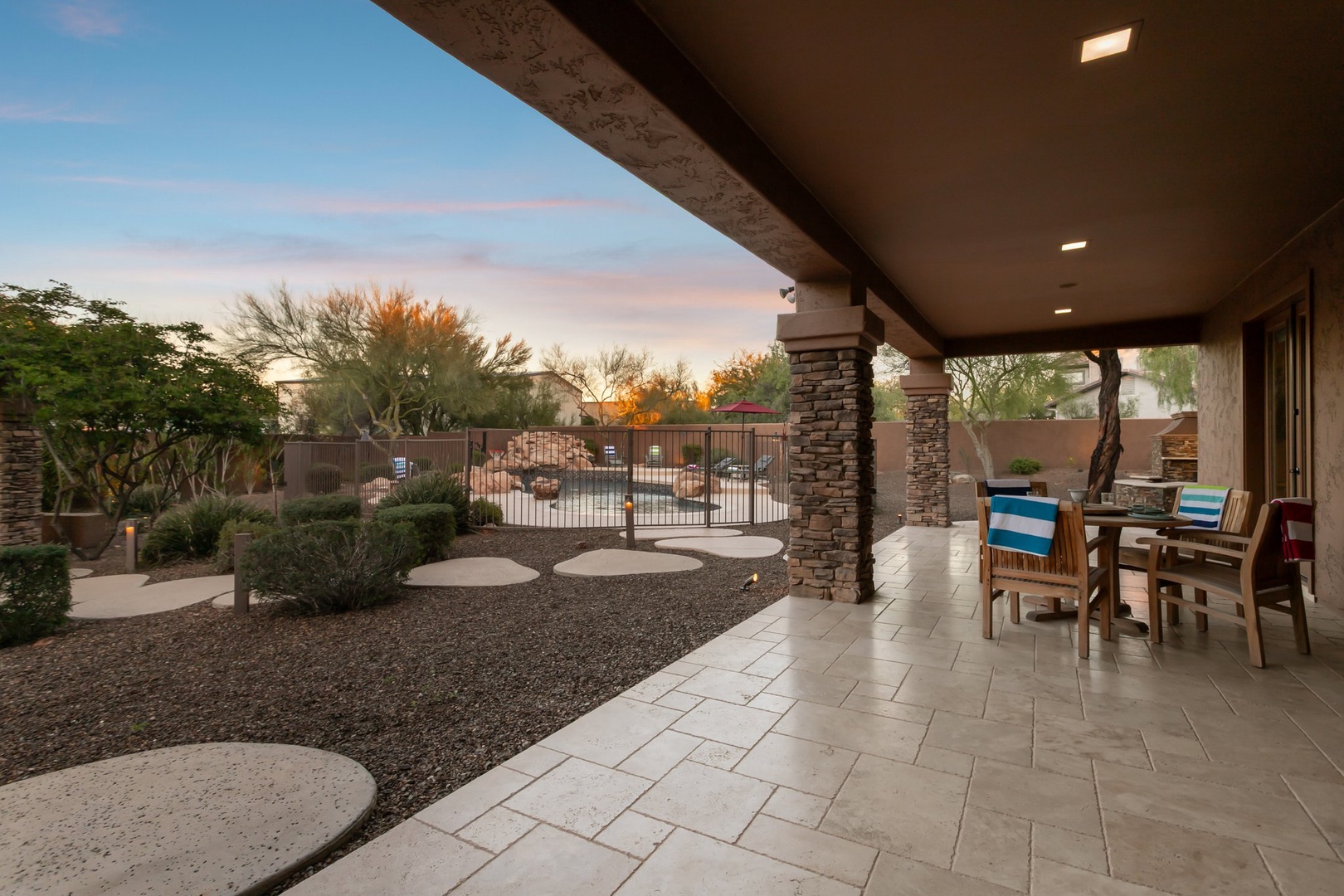 Unwind on your private covered patio as desert twilight paints the sky in soft pastels above the landscaped courtyard.