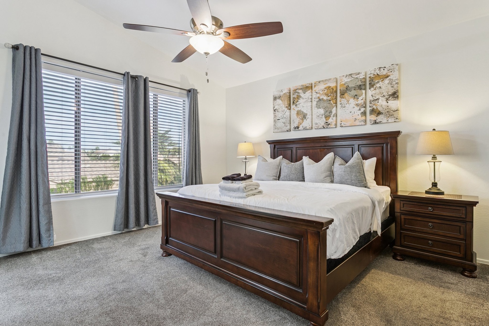 Relax in your elegant bedroom featuring rich wood furniture, plush bedding, and gentle ceiling fan breezes for peaceful nights.