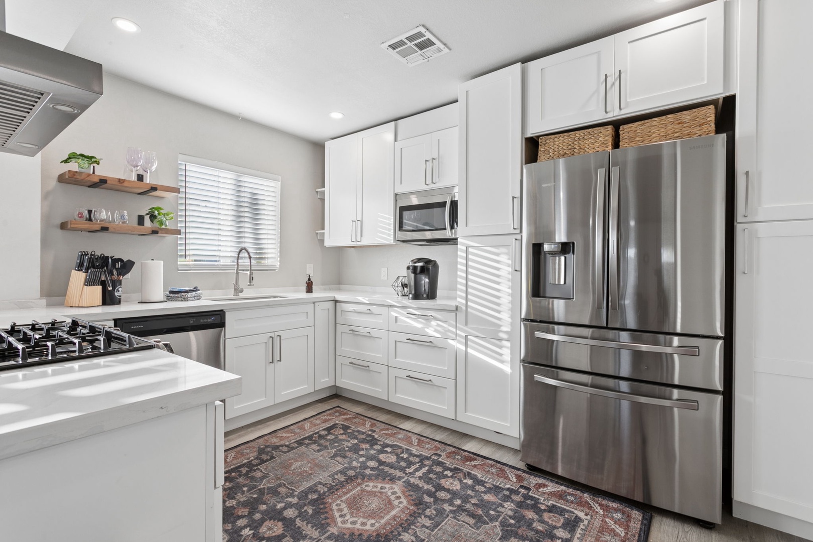 Your gourmet kitchen awaits with gleaming stainless steel appliances, pristine white cabinetry, and ample counter space for preparing memorable meals.