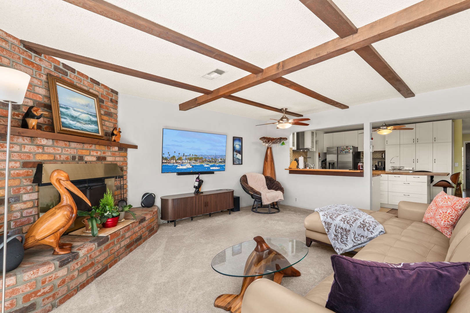 Unwind in your spacious living area with exposed beams, cozy fireplace, and open kitchen perfect for memorable evenings together.