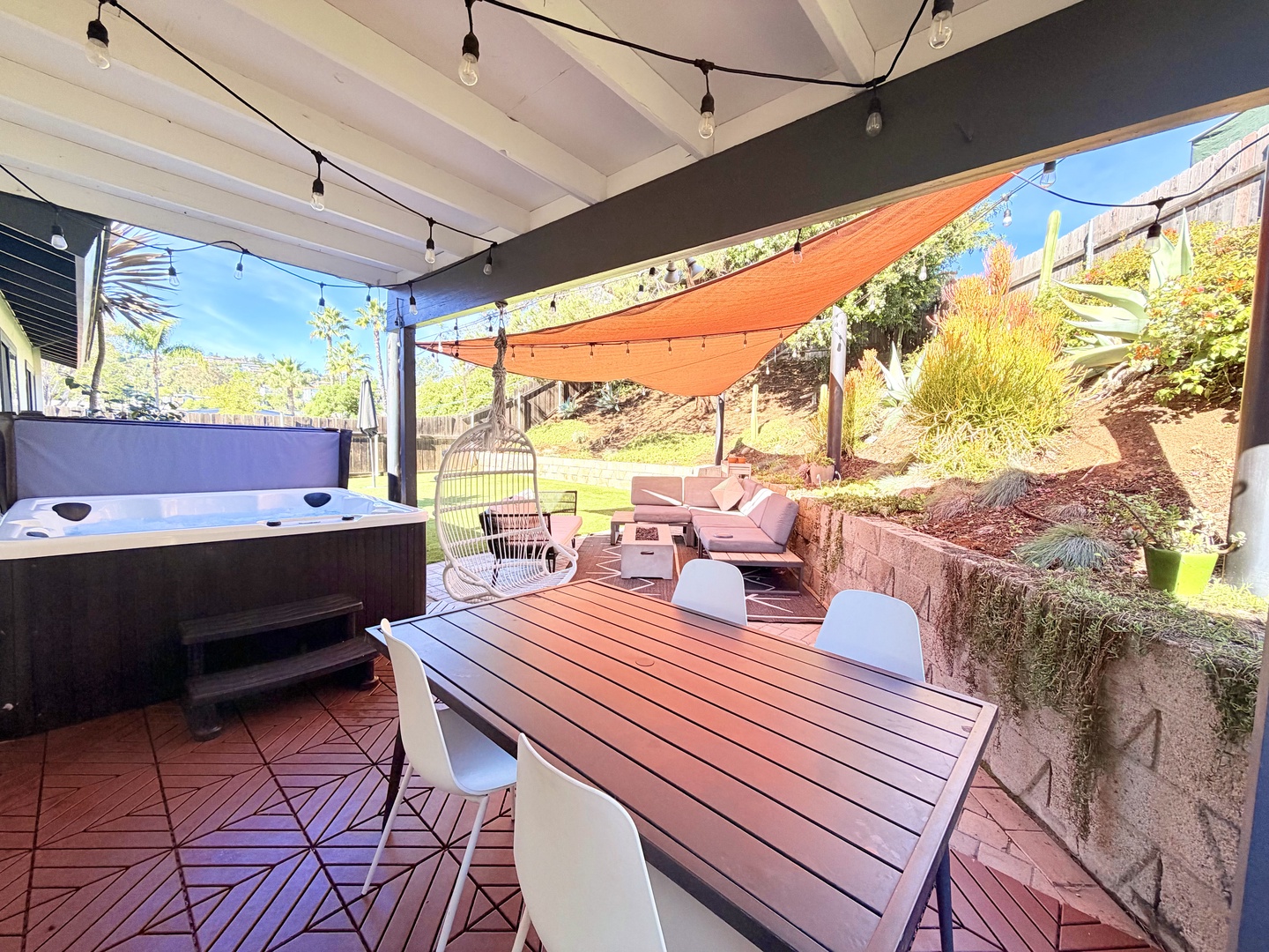 Private backyard with hot tub, dining table, lounge with fire pit, and BBQ Grill