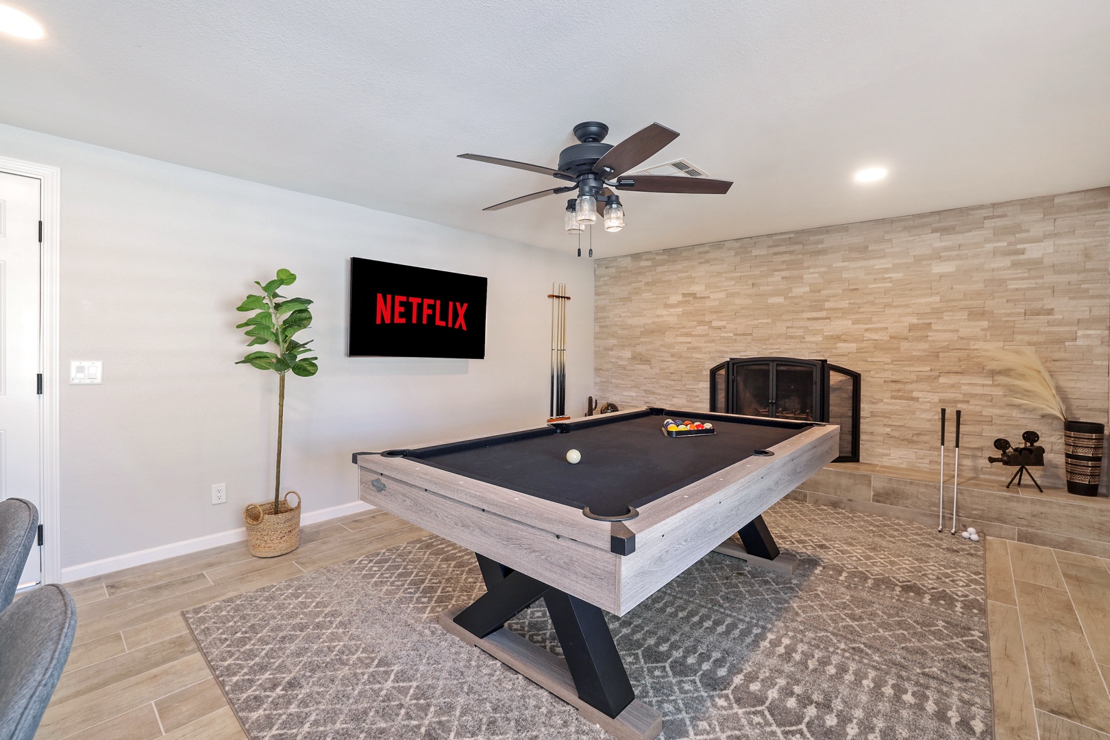 Pool table with a fireplace and smart TV