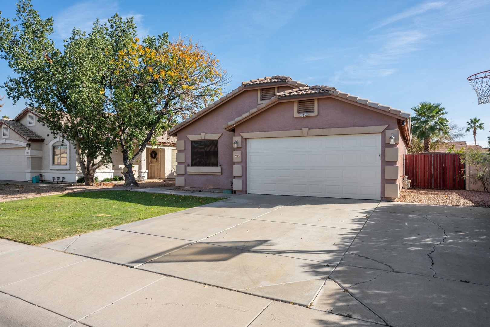 Single-story residential home with driveway parking and palm trees in a quiet neighborhood setting.