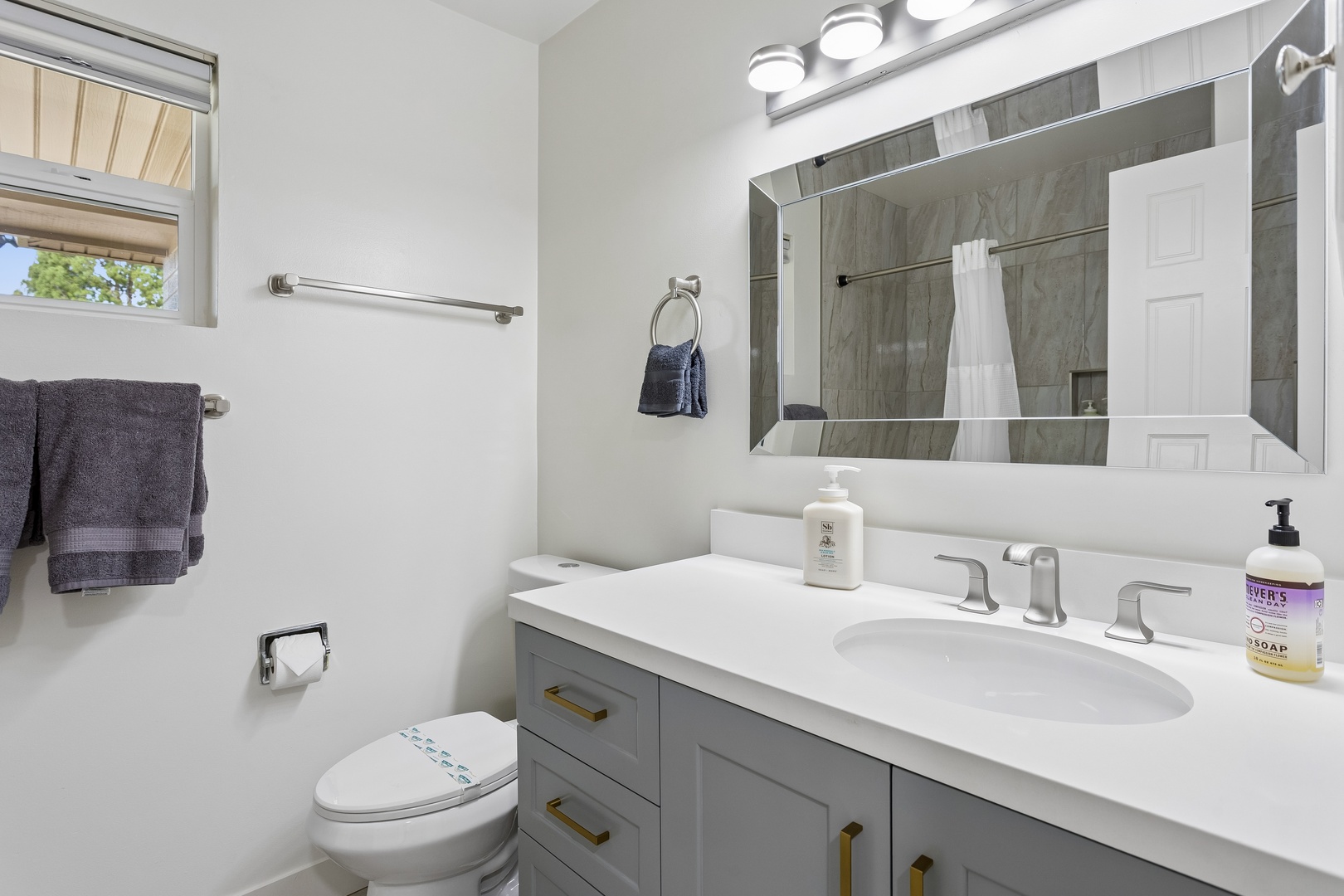 Step into your spotless, modern bathroom with sleek gray finishes, a spacious walk-in shower, and bright lighting—perfectly designed for your comfort and relaxation.