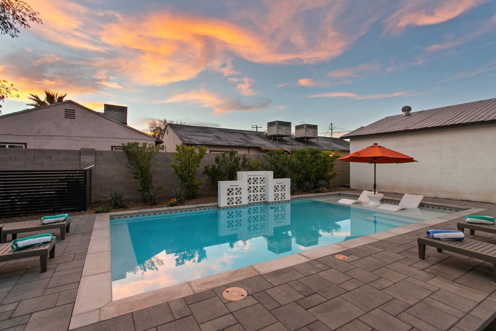 Stunning sunset paints the sky above this private pool oasis, creating perfect ambiance for evening relaxation.