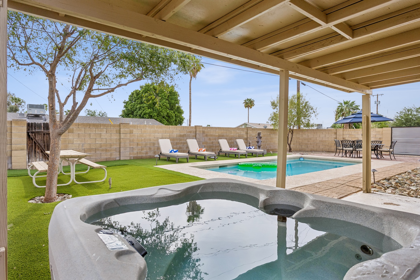 Your private backyard oasis awaits—soak in the hot tub, lounge by the pool, and enjoy sunny Arizona days under a shaded pergola.